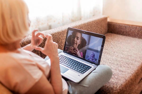 Girl talking with her grandmother within video chat on laptop